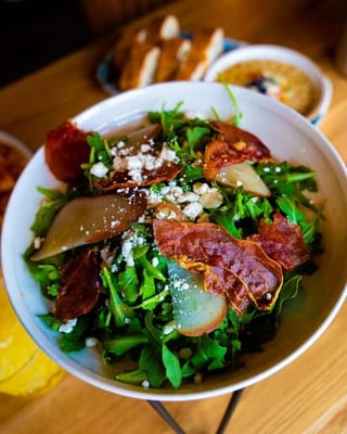 Arugula & Pear salad in a white bowl