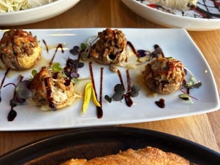 Stuffed Mushrooms with garnish on a white platter