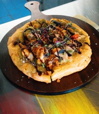 Tuscan Chicken Pesto pizza with glaze and greens